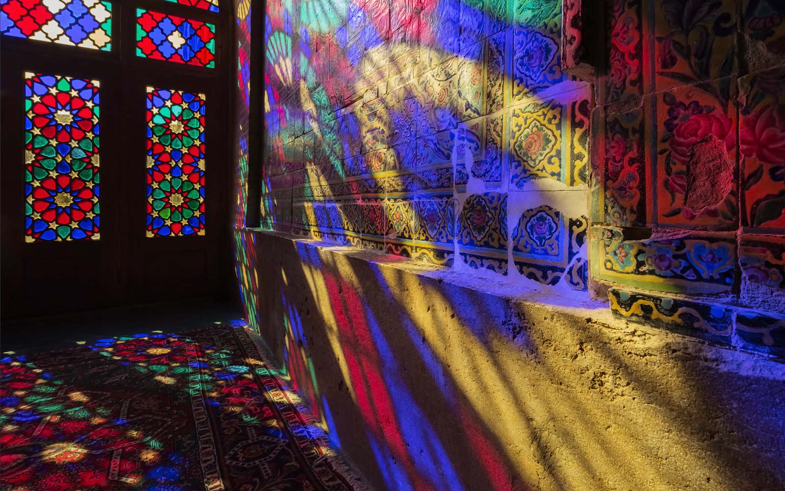 مشهد يُظهر به ضوء ساطع من خلال النوافذ الزجاجية الملونة لعرض الألوان على الجدار (تشغيل الفيديو).
