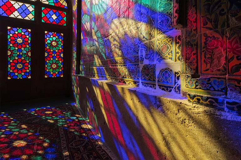 مشهد يُظهر به ضوء ساطع من خلال النوافذ الزجاجية الملونة لعرض الألوان على الجدار (تشغيل الفيديو).