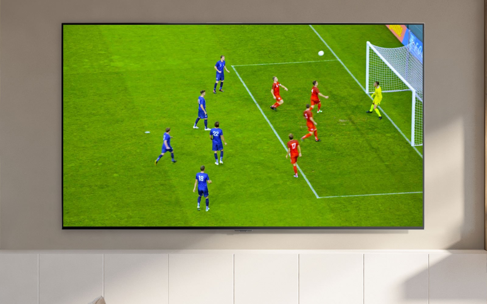 شاشة تلفزيون يظهر عليها مشهد ملغب وأحد لاعبي كرة القدم خلال تسجيل ركلة جزاء (تشغيل الفيديو)