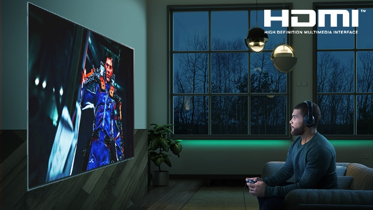 شاشة تلفزيون يظهر عليها رجل جالس على أريكة ممسكا بعصا التحكم أثناء لعبة آر بي جي