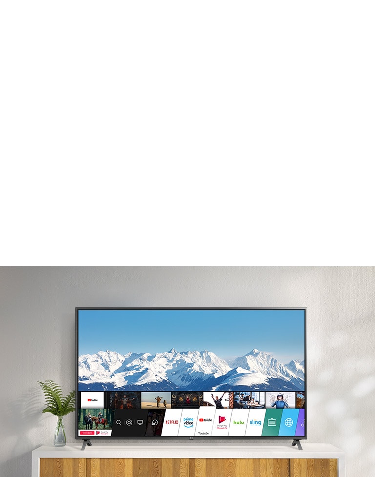 تلفزيون على حامل أبيض مقابل أحد الجدران البيضاء. شاشة تلفزيون تظهر الشاشة الرئيسية مع نظام webOS.
