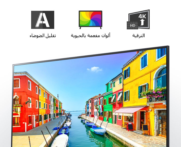 شاشة تلفزيون تعرض مشهدا لمدينة ساحلية تتميز فيها البنايات بطلاء متعدد الألوان كما ترسو القوارب الصغيرة في ميناء طويل وضيق.