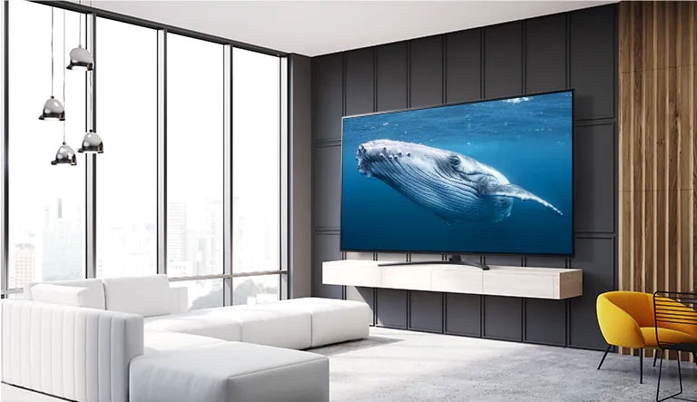 في غرفة المعيشة، يوجد تلفاز بشاشة كبيرة تعرض صورة لحوت كبير في البحر. 