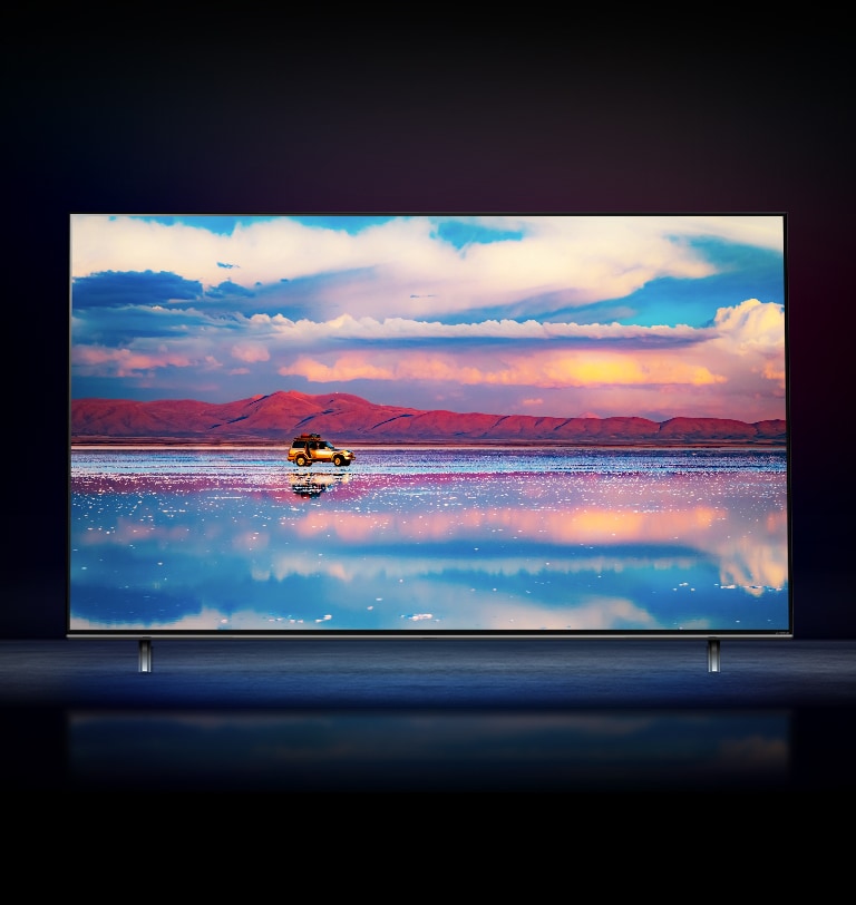 تلفاز LG NanoCell على خلفية سوداء.  يعرض التلفاز سيارة تسير أمام سلسلة جبال منخفضة في المياه التي تعكس السماء المفعمة بالحيوية. 
