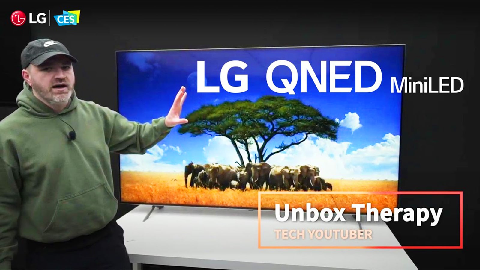 يقف Tech YouTuber Unbox Therapy أمام تلفزيون  QNED MiniLED من إل جي. يظهر على الشاشة صورة لقطيع من الأفيال حول إحدى الأشجار.