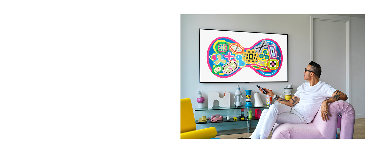 كريم رشيد، المصمم الصناعي، جالس على أريكة يشاهد تلفزيونًا يعرض لوحة فنية. 