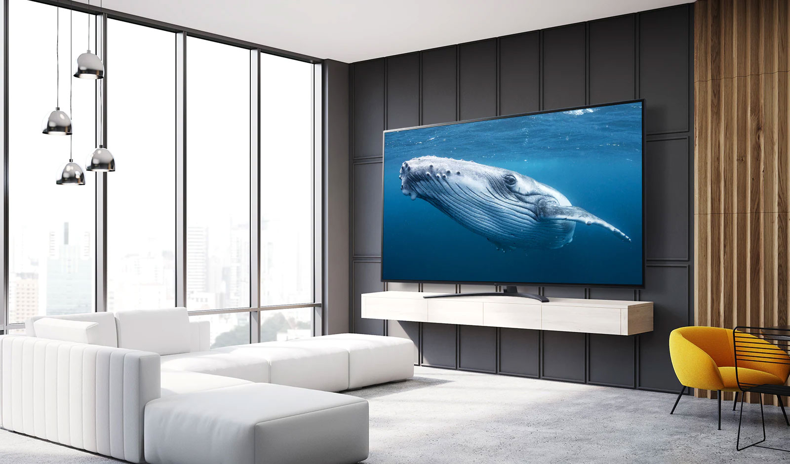 In a living room, there is a large screen TV displaying an image of a big whale in the sea.