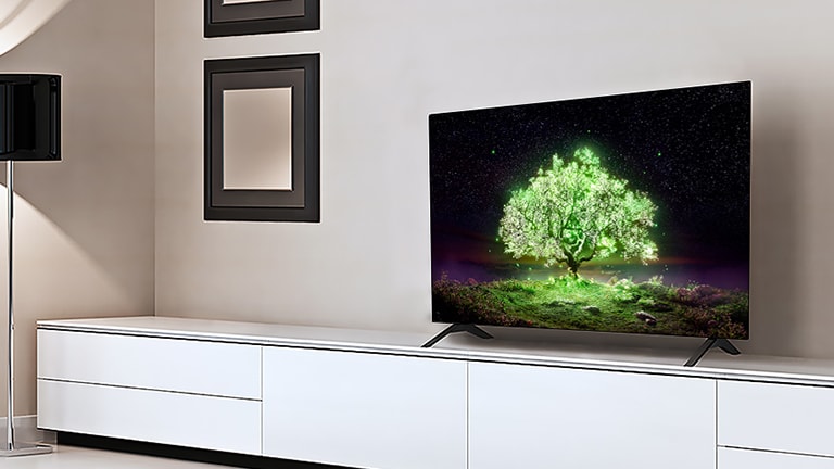 A TV displaying a shining green tree is in an living room.