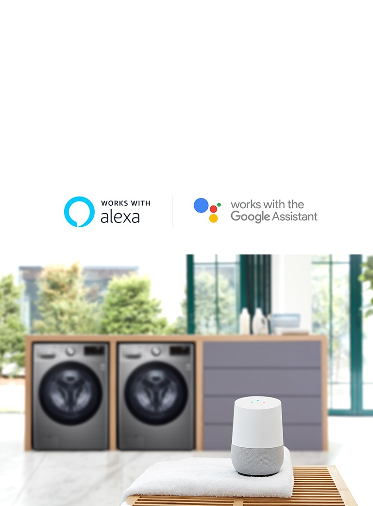 Background of the image is two washing machine front loading washers in a built in folding station slightly blurred with the LG ThinQ sitting on a towel on a table in the foreground.