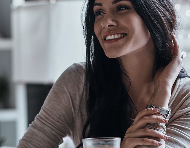 A woman is staring at something with a bright smile.