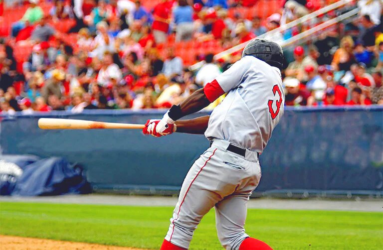 A baseball player swinging the bat during a game in front of the crowd in a stadium.