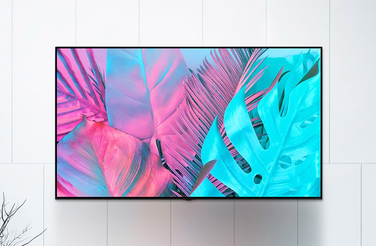 A large flatscreen TV mounted against a white wall. The screen shows large leaves in bright colors.