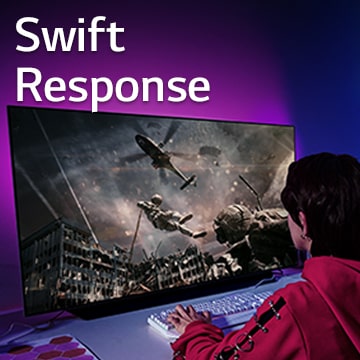 A girl is playing computer game with a large screen TV displaying a soldier coming down from a helicopter.